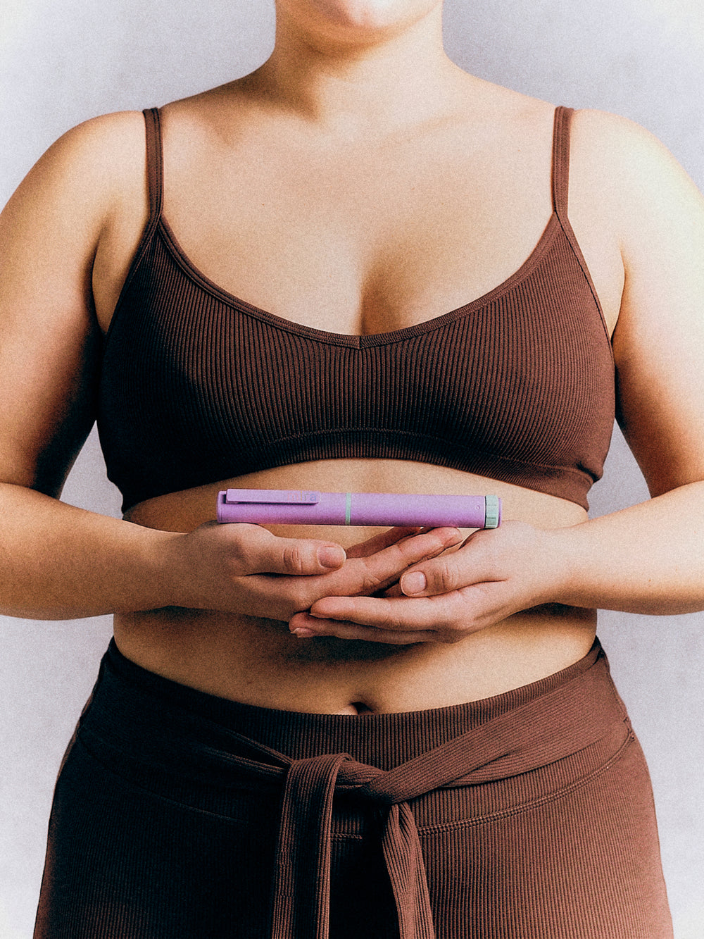 A woman holding the Mira pen in both hands at her waist
