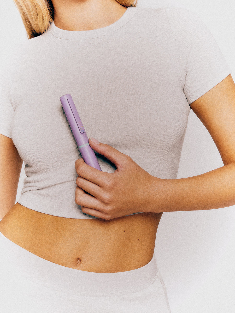 A woman holding the Mira pen against her side